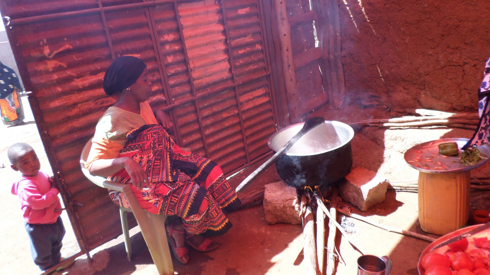 A woman in the informal settlement of Kibera in Nairobi, Kenya prepares a meal on a traditional stone hearth. Firewood generates significant quantities of pollutants, making users vulnerable to  respiratory illnesses such as pneumonia.