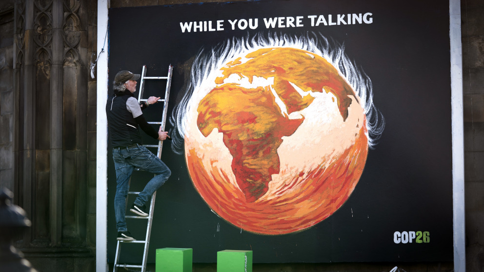 COP26 in Glasgow: Der Künstler Greg Mitchell stellt sein Wandgemälde zur Klimakrise fertig, das die brennende Erde zeigt.