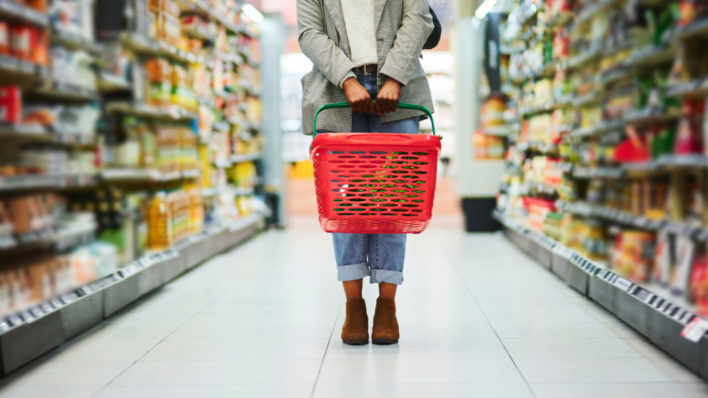 Frau mit Einkaufskorb in Supermarkt
