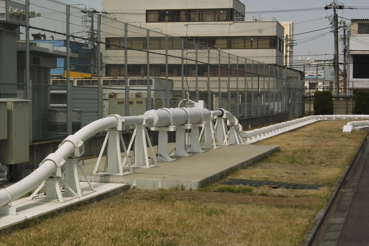 TEPCO/Sumitomo 66 kV-Wechselstrom- (AC) HTS-Teststation am Asahi-Umspannwerk in Yokohama /Japan. Das Foto zeigt den Kryostat, der die Standardleitung bei Umgebungstemperaturen mit dem Supraleiter bei sehr viel niedrigeren Temperaturen um die 70 Grad Kelvin verbindet. © Heiko Thomas