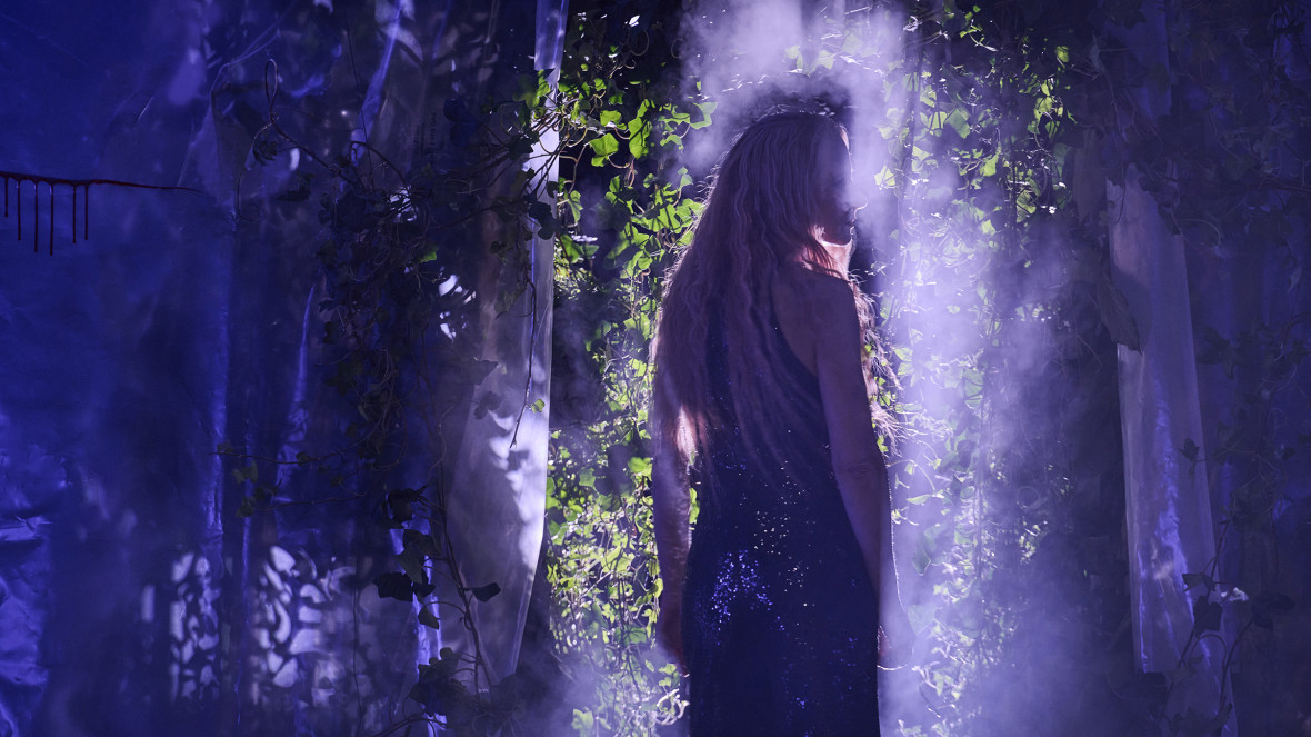 A step into uncharted territory: actor Kristin Muthwill performs in "eure paläste sind leer" against a backdrop of recycled fabrics and plants sourced from Potsdam's Biosphere Centre.